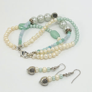 Fresh water pearls accompany minty green and palest blue glass beads on a triple strung bracelet and matching dangle earrings.