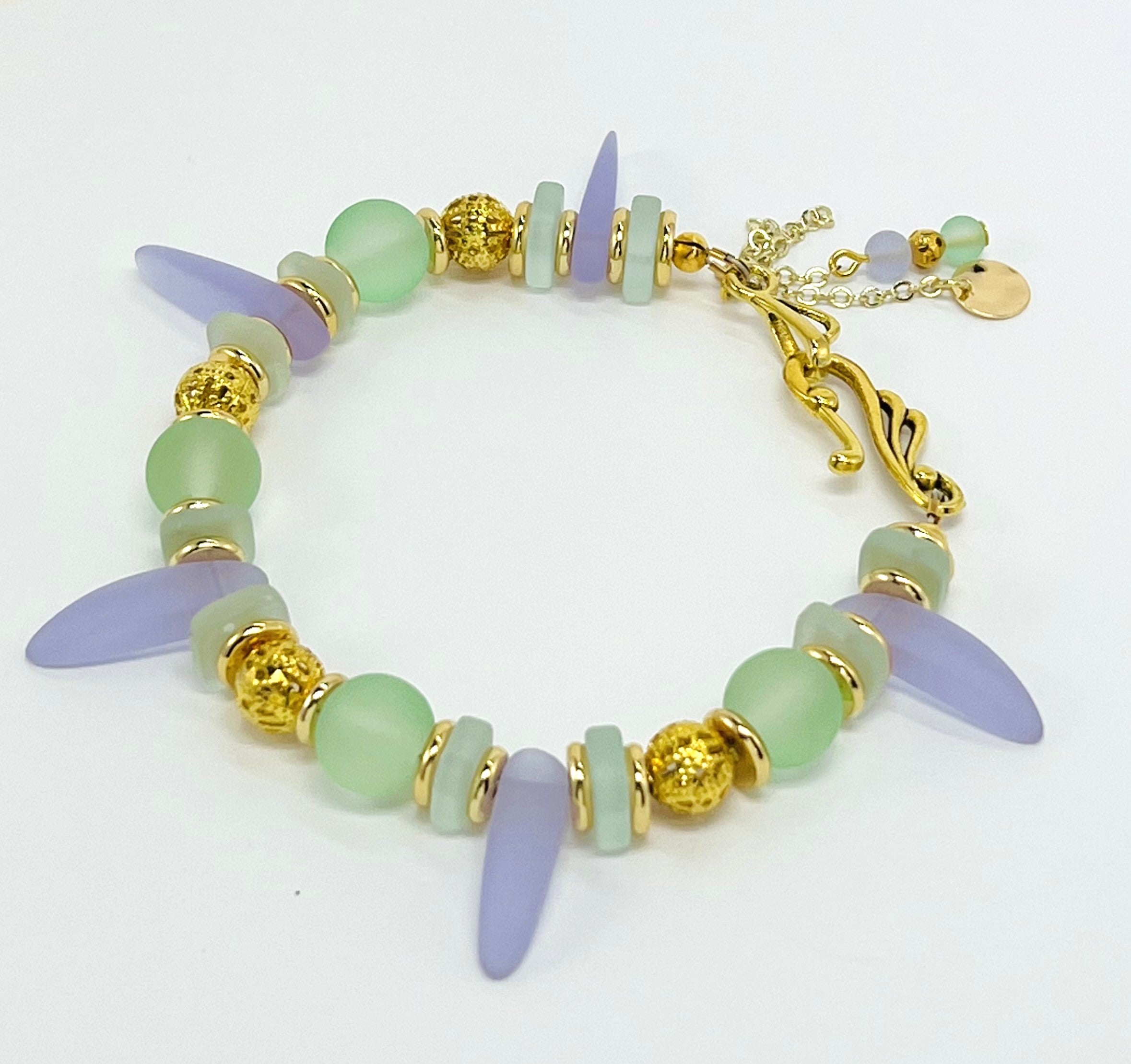 Sensitive lilac and mint green sea glass beads complimented with gold plated accents bracelet and earring set