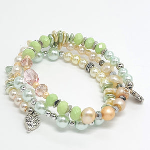 Playful pastels of green, peach, cream glass beads and fresh water pearls with silver plated accents and charms