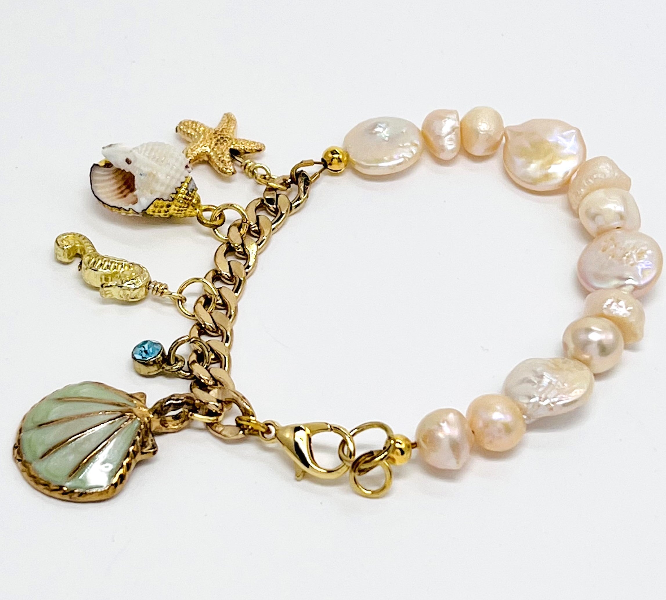 Sophisticated charm bracelet with fresh water and coin pearls and assorted gold plated chain and sea life charms