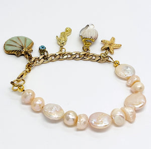 Sophisticated charm bracelet with fresh water and coin pearls and assorted gold plated chain and sea life charms