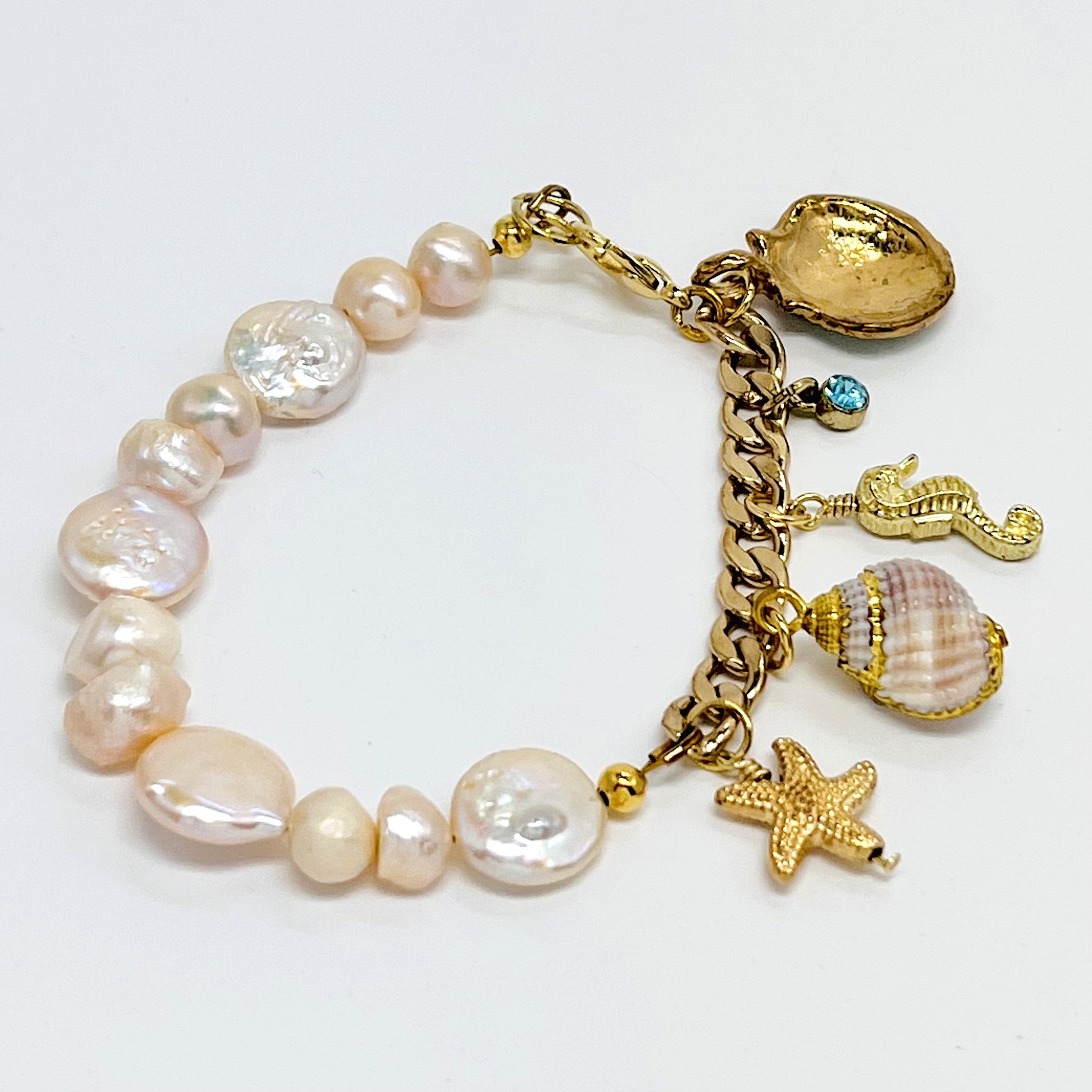 Sophisticated charm bracelet with fresh water and coin pearls and assorted gold plated chain and sea life charms