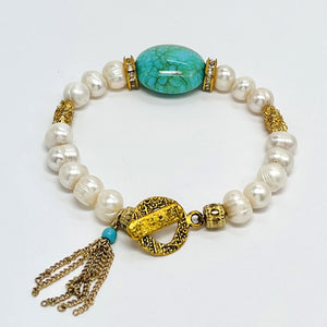 Fresh water pearl beaded bracelet with gold plated metal elements and an acrylic turquoise focal bead