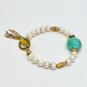 Fresh water pearl beaded bracelet with gold plated metal elements and an acrylic turquoise focal bead