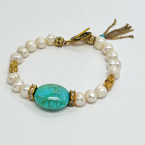 Fresh water pearl beaded bracelet with gold plated metal elements and an acrylic turquoise focal bead