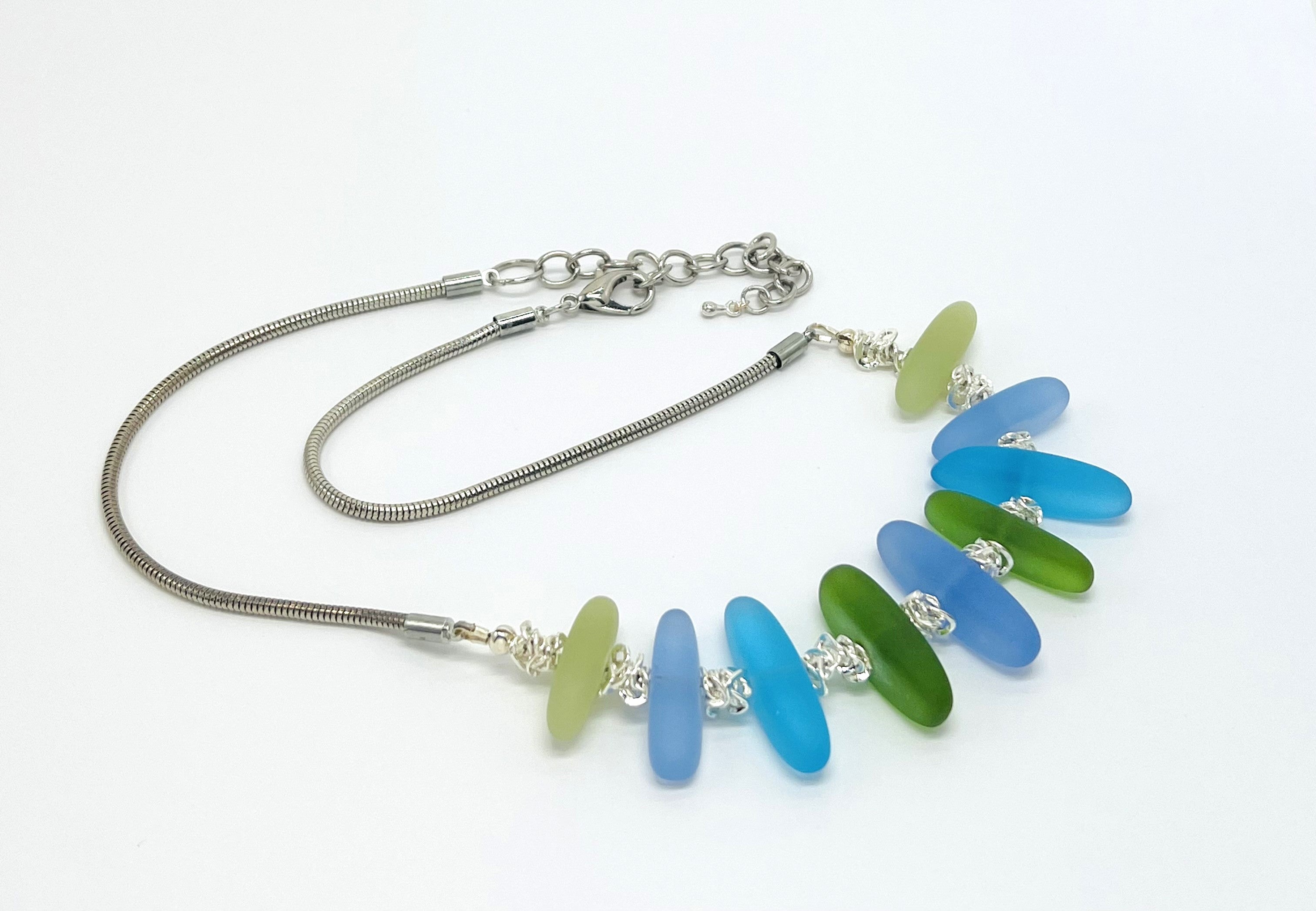 Cool Caribbean sea colors in frosty blue and green sea glass beads hanging on a silver plated snake chain with matching earrings