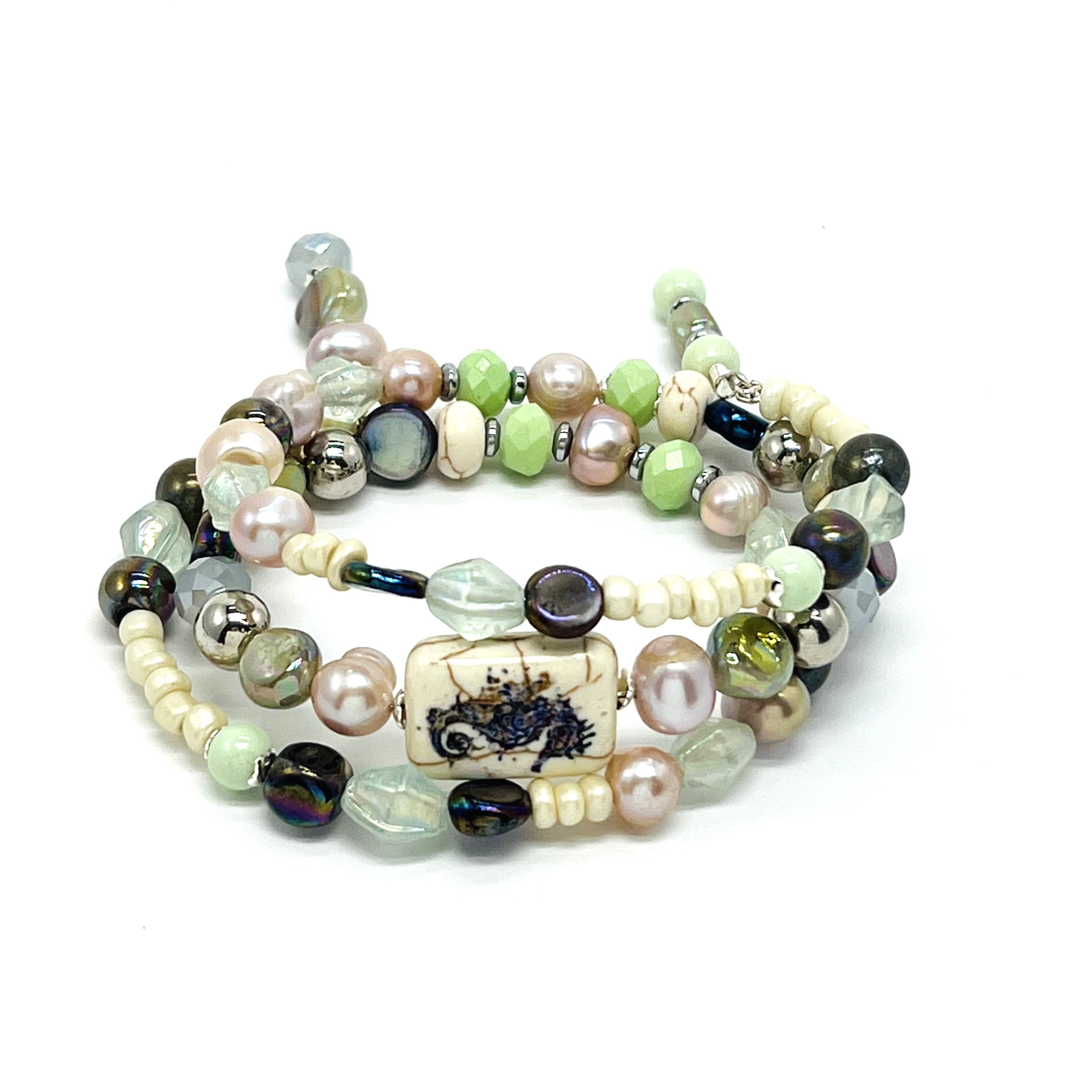 Beachy memory wire bracelet in cool cream, green, purple and lavender beads with silver seahorse accents