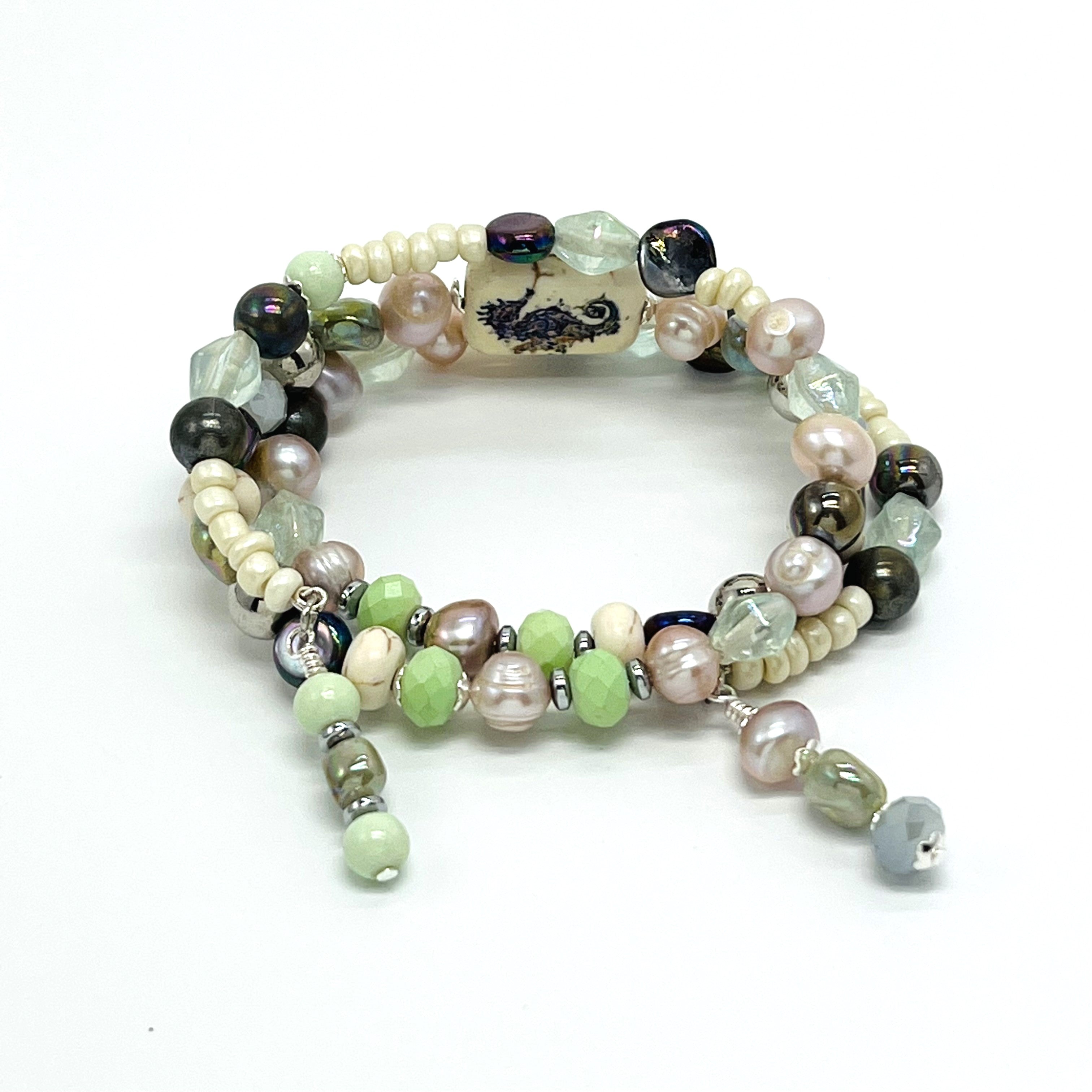 Beachy memory wire bracelet in cool cream, green, purple and lavender beads with silver seahorse accents