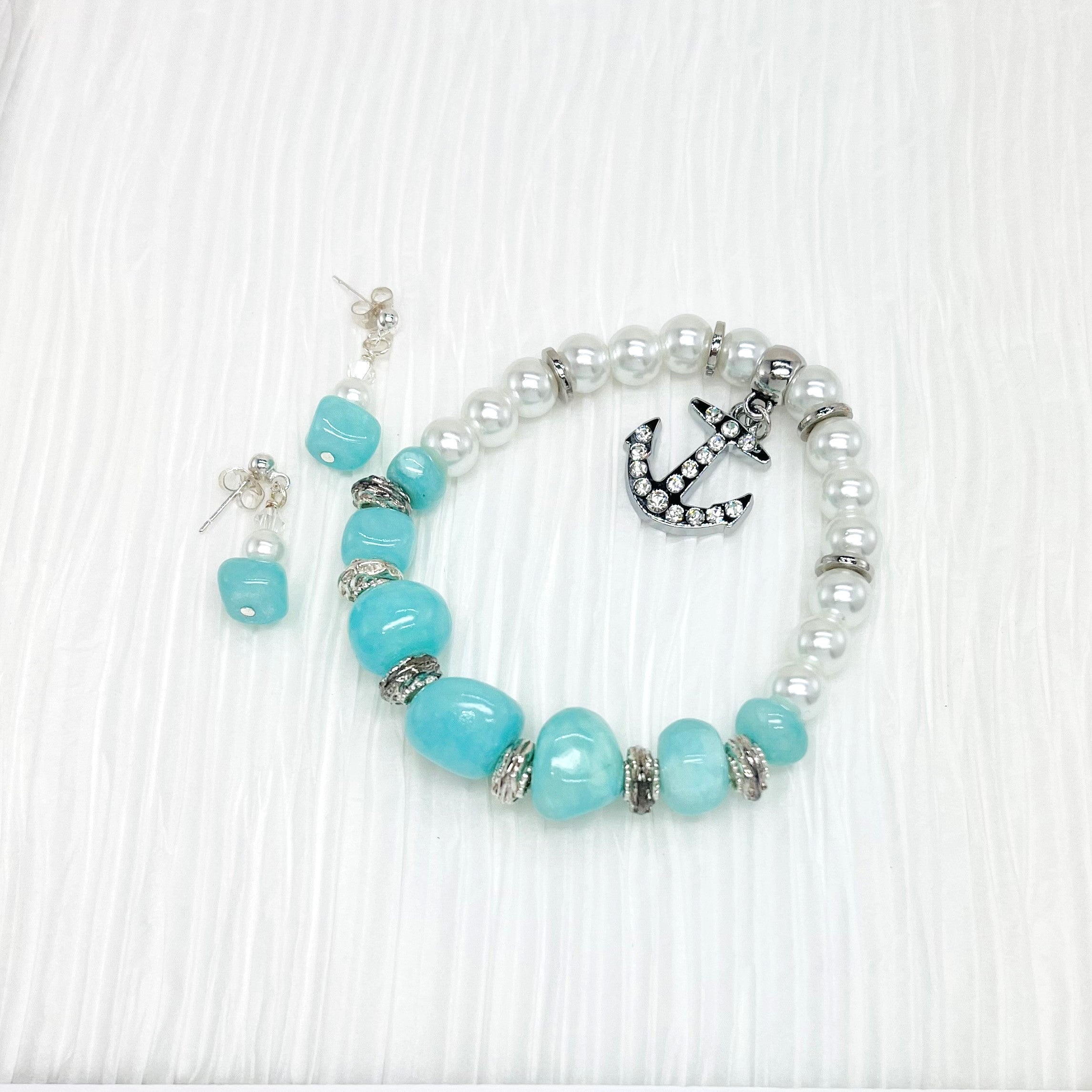 Bracelet and earring set in Caribbean blue stone beads, white pearls with silver accents and a silver rhinestone encrusted anchor