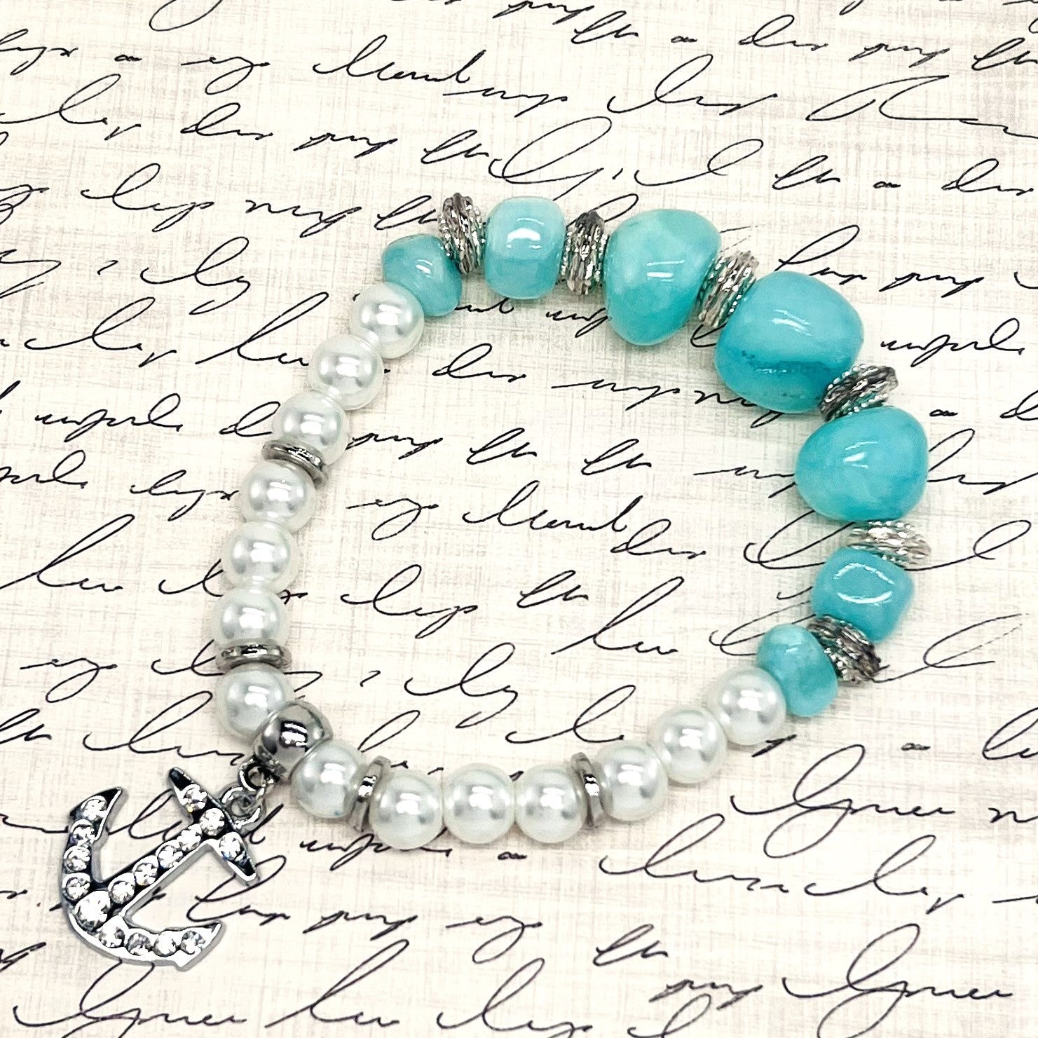 Bracelet and earring set in Caribbean blue stone beads, white pearls with silver accents and a silver rhinestone encrusted anchor