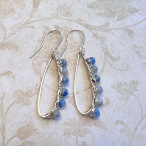 Inspiring blue and gray Sodalite gemstone beads are artistically wire wrapped with silver wire to make lovely earrings