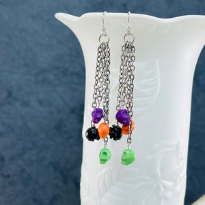 Halloween fun earrings green, orange, purple skulls and a black resin flower, silver ear wires