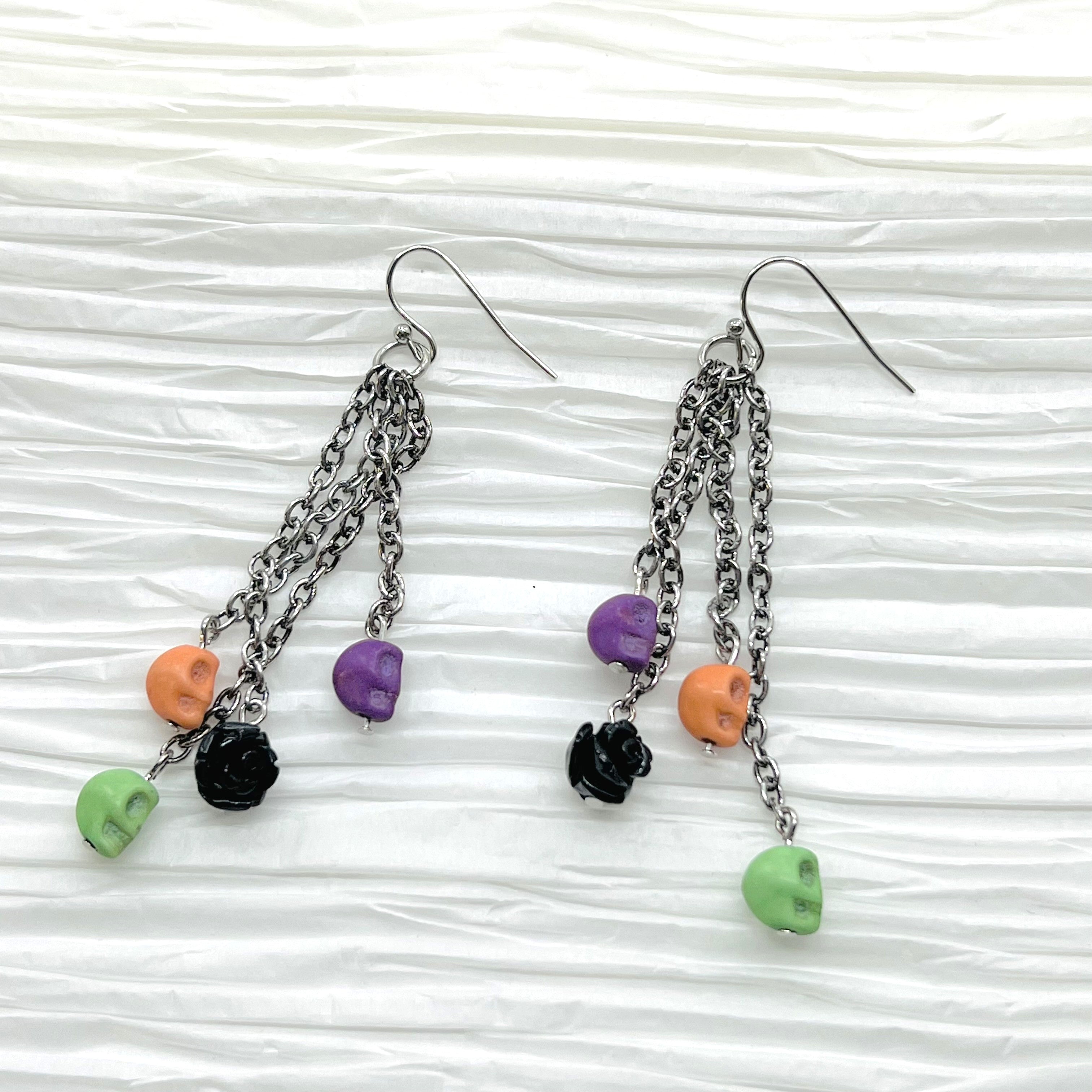 Halloween fun earrings green, orange, purple skulls and a black resin flower, silver ear wires