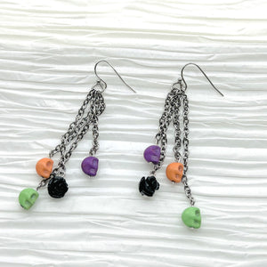 Halloween fun earrings green, orange, purple skulls and a black resin flower, silver ear wires