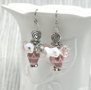 Fancy pink Wagnerite skull earrings topped with a row of lovely pink, white and silver resin flowers