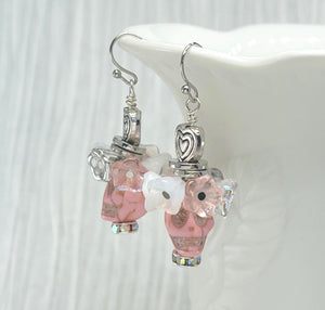 Fancy pink Wagnerite skull earrings topped with a row of lovely pink, white and silver resin flowers