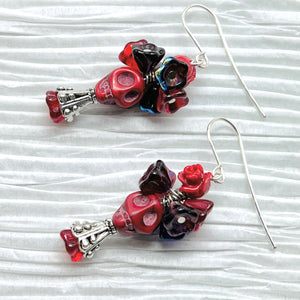 Passionate red Wagnerite skull earrings topped with a row of colorful resin flowers in red, blue and purple