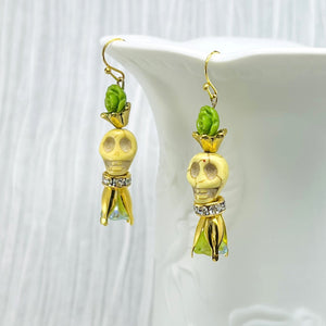 Lovely pale yellow Wagnerite skull earrings with green resin flowers accented in gold