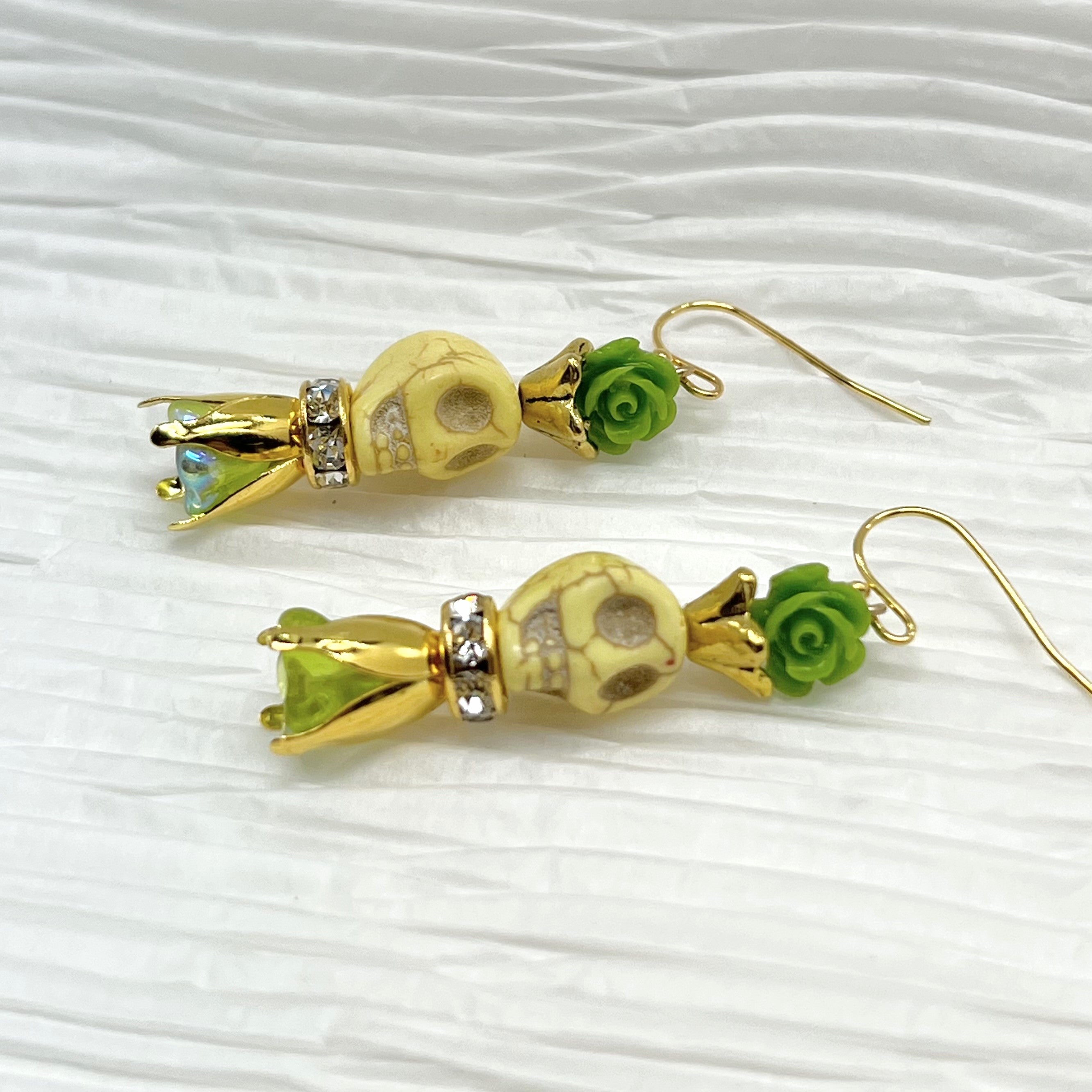 Lovely pale yellow Wagnerite skull earrings with green resin flowers accented in gold