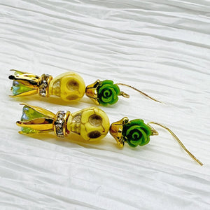 Lovely pale yellow Wagnerite skull earrings with green resin flowers accented in gold