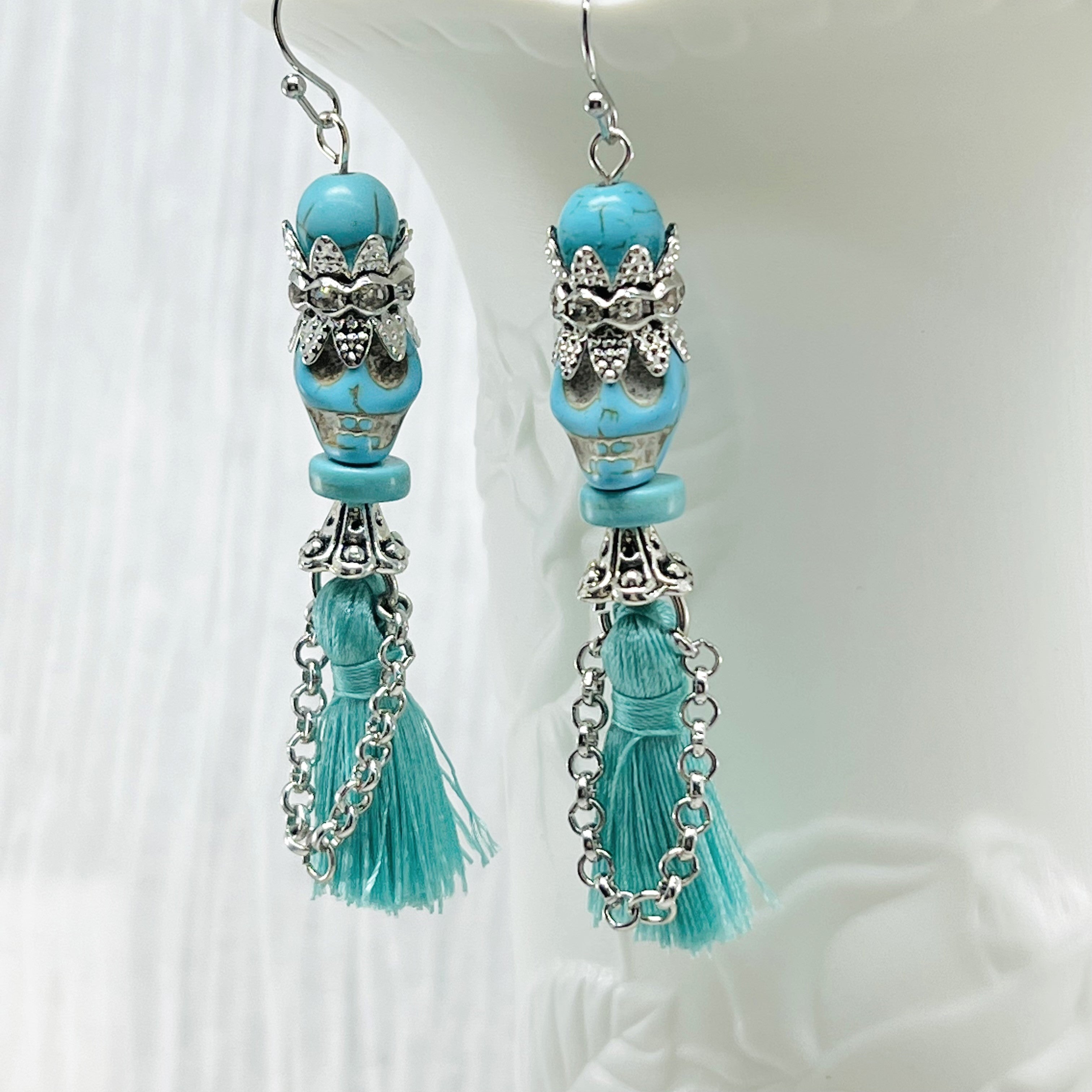 Fancy turquoise Wagnerite skull earrings with sparkling crown and tassel skirt