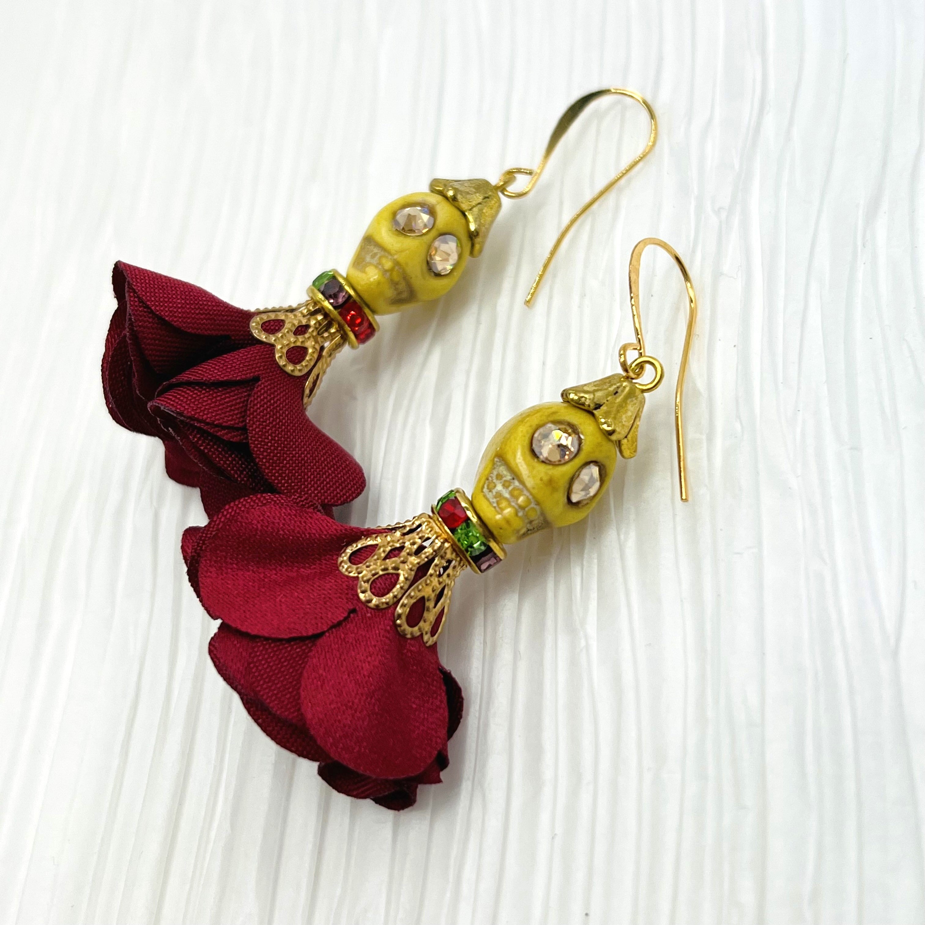 Lovely yellow Wagnerite skull earrings with sparkly eyes and a flowing silk dark red maroon skirt