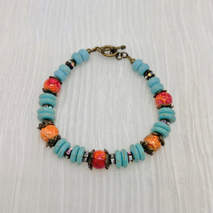 Bracelet and earring set in antique bronze, turquoise howlite and orange glass beads