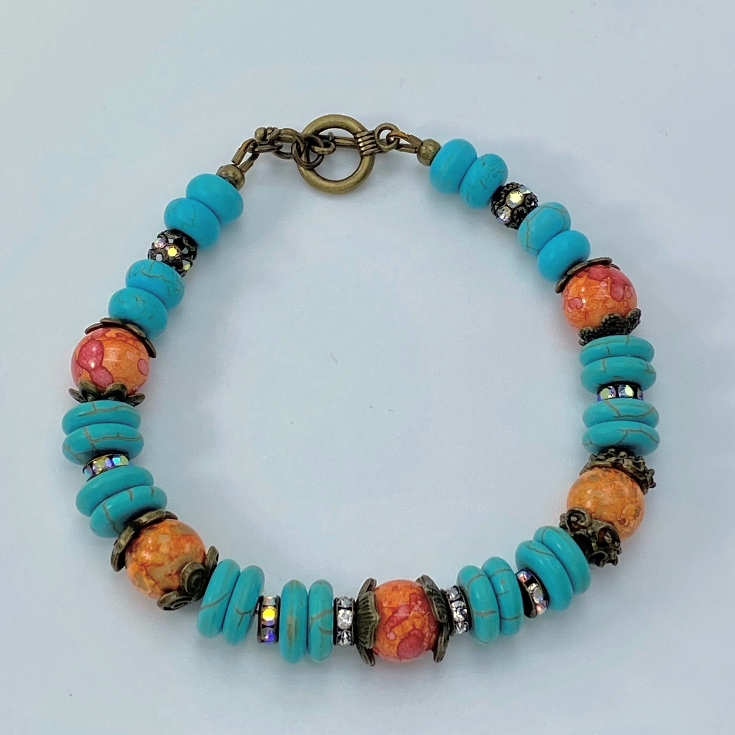 Bracelet and earring set in antique bronze, turquoise howlite and orange glass beads