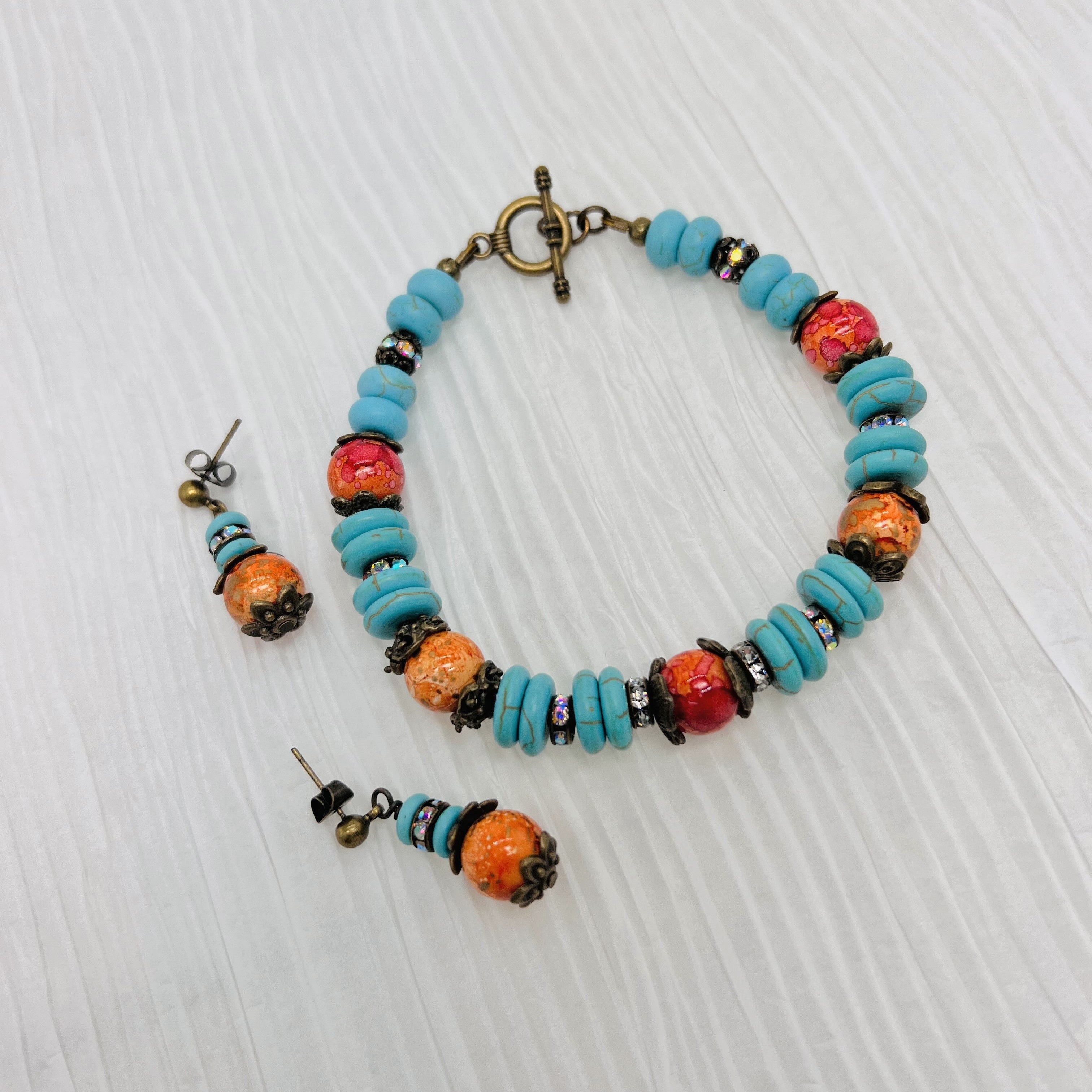 Bracelet and earring set in antique bronze, turquoise howlite and orange glass beads